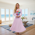 Gorgeous positive woman in pink hearts dress in bright sunny coastal living room