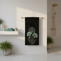 Sophisticated bathroom with black teal gold botanical beach towel hanging on brass bar