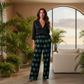 Woman in green leaf pants with black shirt in botanical setting